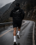 Ghost Run Club runner in hoodie on mountain road